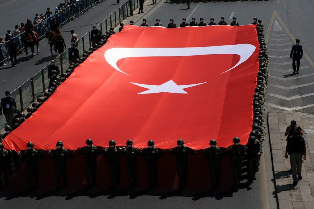 Turkish soldiers carrying the national flag during a public ceremony